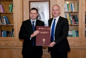Ректор REA-Stockholm School of Economics in Riga Андерс Паалзов (Anders Paalzow) вручил премьеру Латвии объемистый том.  Рига. 20.04.2012. Пресс-фото. 