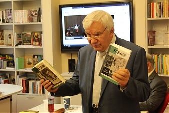 Поэт Пётр Антропов иллюстрирует свой доклад книгами о Сергее Есенине из серии ЖЗЛ. Фото Владимира Старкова.